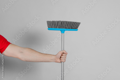 Man with broom on grey background  closeup