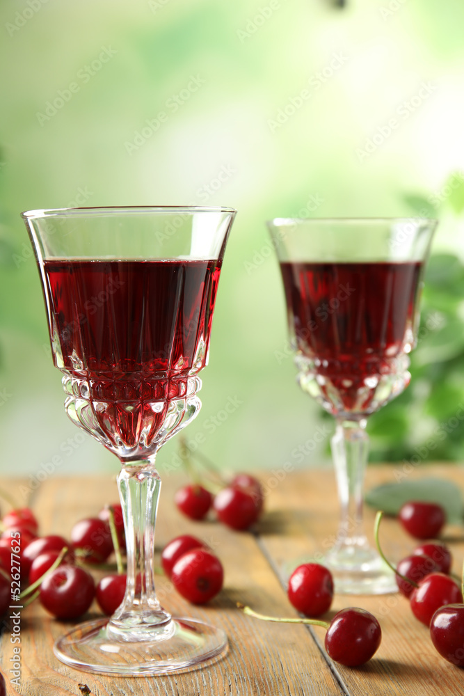 Delicious cherry wine with ripe juicy berries on wooden table Delicious cherry wine with ripe juicy berries on wooden table