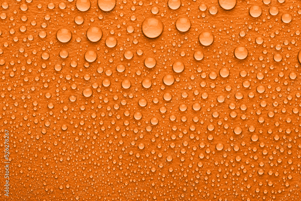 Water drops on orange background, top view Water drops on orange background, top view