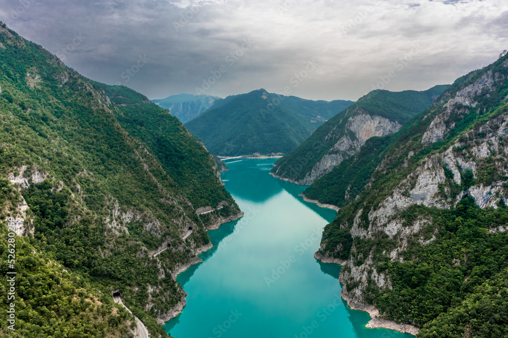 Piva Lake - Amazing Mountain View in Montenegro / Alps Landscape - turquoise blue water on Balkan with main Mountain in the middle - wide aerial drone shot