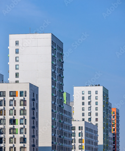 Monolithic white residential apartment buildings district on blue sky © Aguus