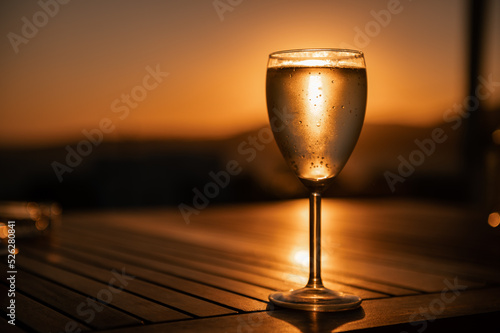 Traditional house white wine served in tavern  traditional greece drink  mazing sunset as background