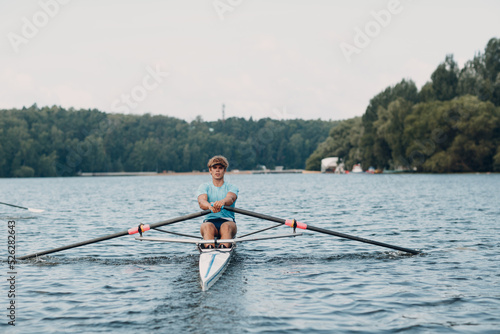 Sportsman single scull man rower rowing technique on boat. Paddle oar splash movement