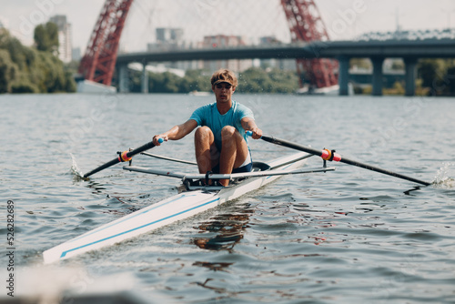 Sportsman single scull man rower rowing on boat at Moscow River Russia
