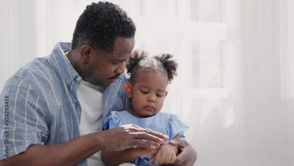 A father cleans his daughter skin or applies medicine to prevent dermatitis in children. A father cleans his daughter skin or applies medicine to prevent dermatitis in children.