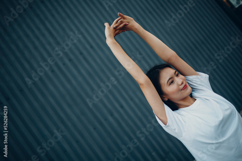 Asian young woman doing qigong yoga stretching pilates exercise summer outdoor.