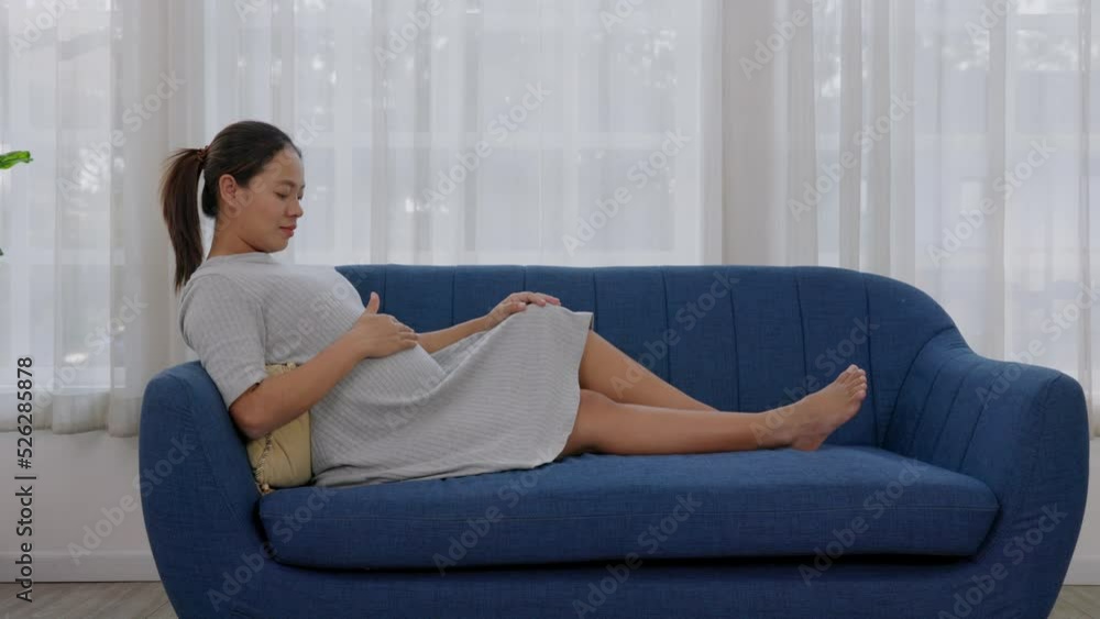 A pregnant woman touches her belly to detect the movement of her unborn child A pregnant woman touches her belly to detect the movement of her unborn child