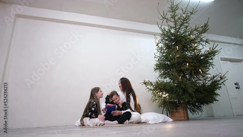 Mom with kids writes a letter to Santa Claus. Happy family on New Year's Eve. Christmas comfort  photo