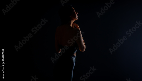 Silhouette of girl is posing while looking around