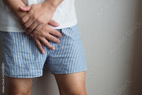 Man using his hands touching and covering his crotch suffering from his genitourinary system or genital organ problem Man healthcare and urinary incontinence concept