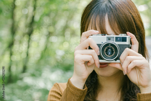 日本の女性がカメラを持って緑の中にいる woman photographer