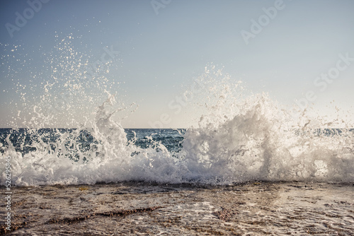 Morning sea shore with splashing waves background and sky on the horison.