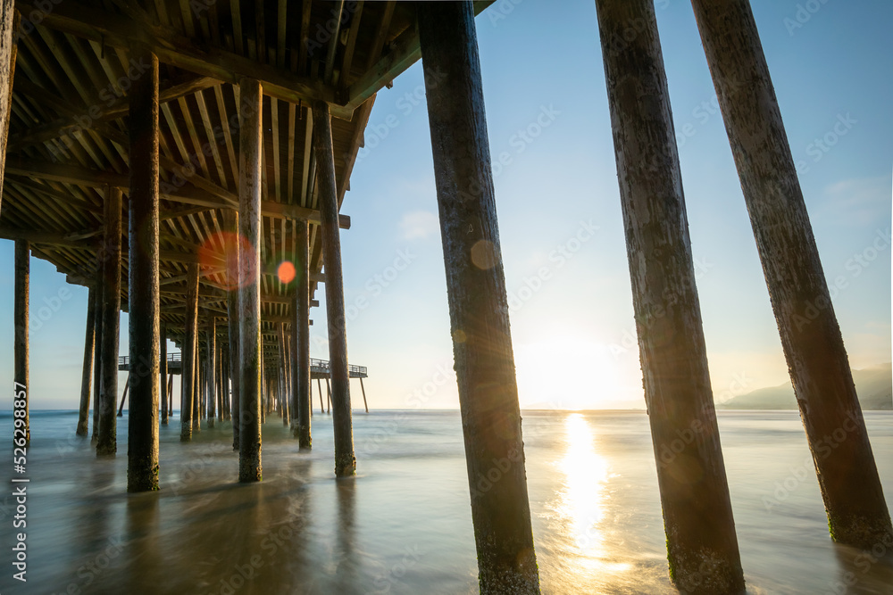 wooden pier on the beach at sunset