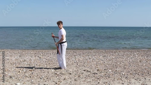 Teenage Boy Doing Karate on A Beach photo