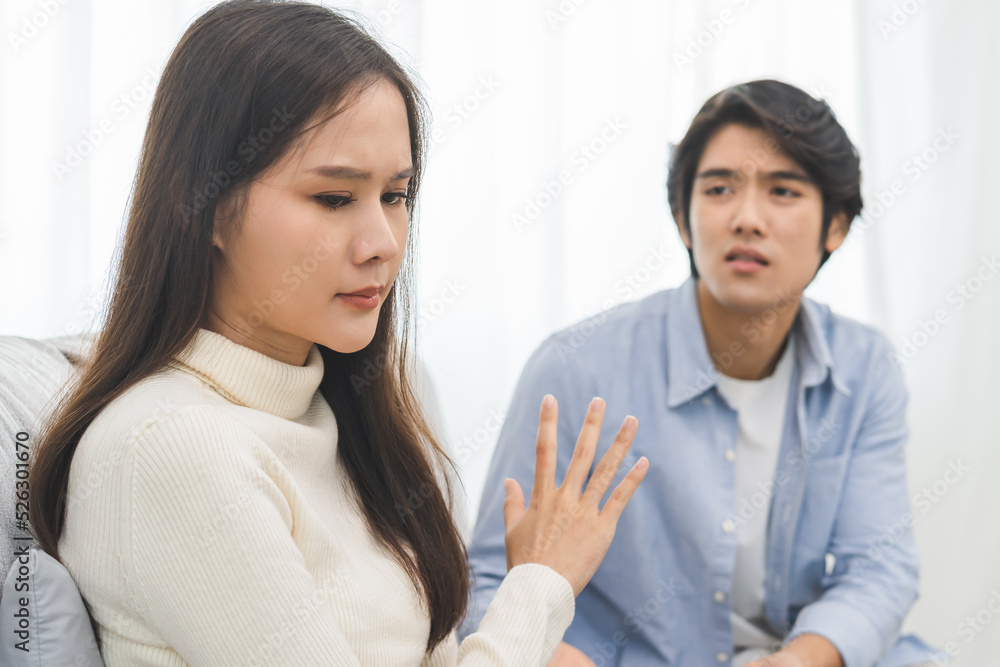 Family problems, Asian women cover her face and sit separately from husband feel disappointed after quarrels at home. Family problems, Asian women cover her face and sit separately from husband feel disappointed after quarrels at home.
