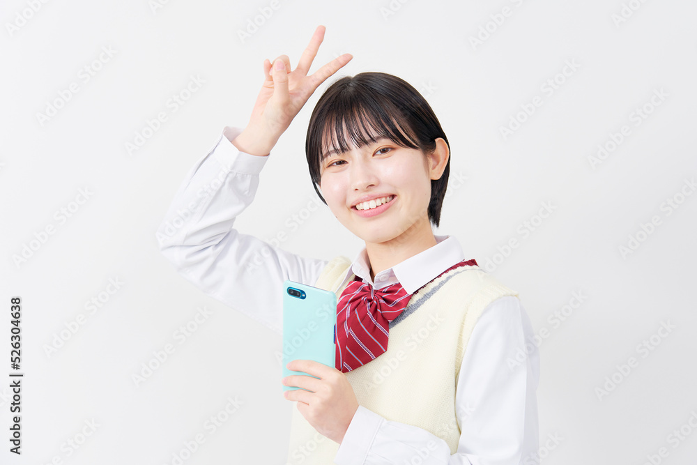 白背景でスマホを持ってピースする女子高生 白背景でスマホを持ってピースする女子高生