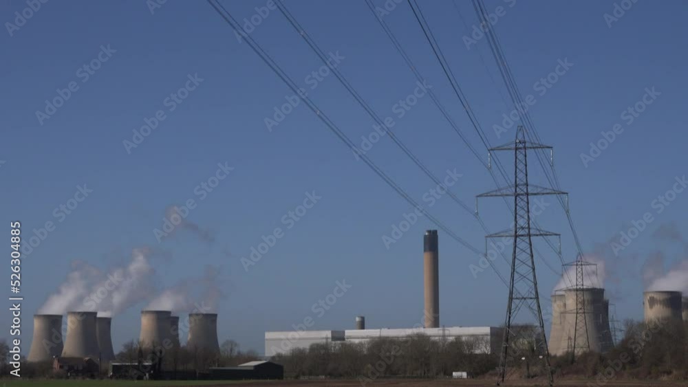 Wind turbines and coal fired power station in background. Carbon intensive and neutral together old and new power generation together UK 4K Wind turbines and coal fired power station in background. Carbon intensive and neutral together old and new power generation together UK 4K