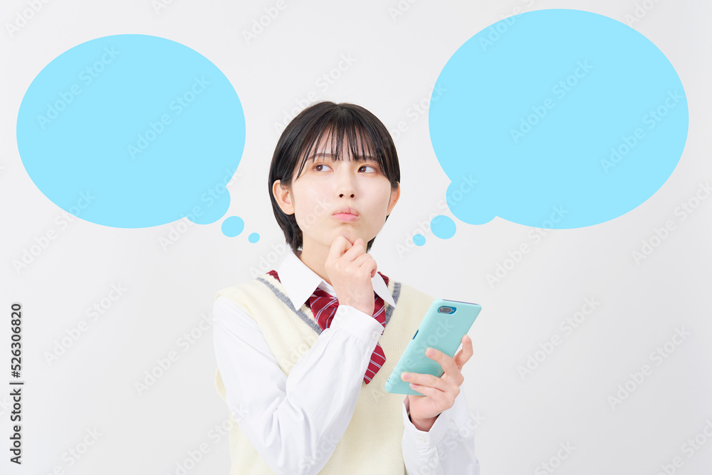 白背景でスマホを持って悩む女子高生 吹き出しあり 白背景でスマホを持って悩む女子高生 吹き出しあり
