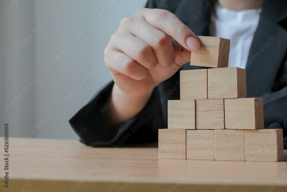 Hand putting wood cube on top of wood block stacking as step stair. business growth to success. Hand putting wood cube on top of wood block stacking as step stair. business growth to success.