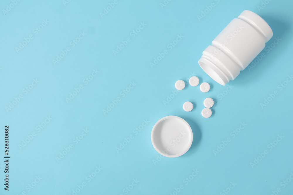 Pills and bottle on blue background pharmacy and hospital concept. copy space, top view.