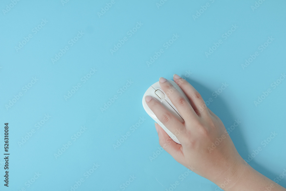 Woman using computer mouse on blue background, top view. Space for text. Woman using computer mouse on blue background, top view. Space for text.