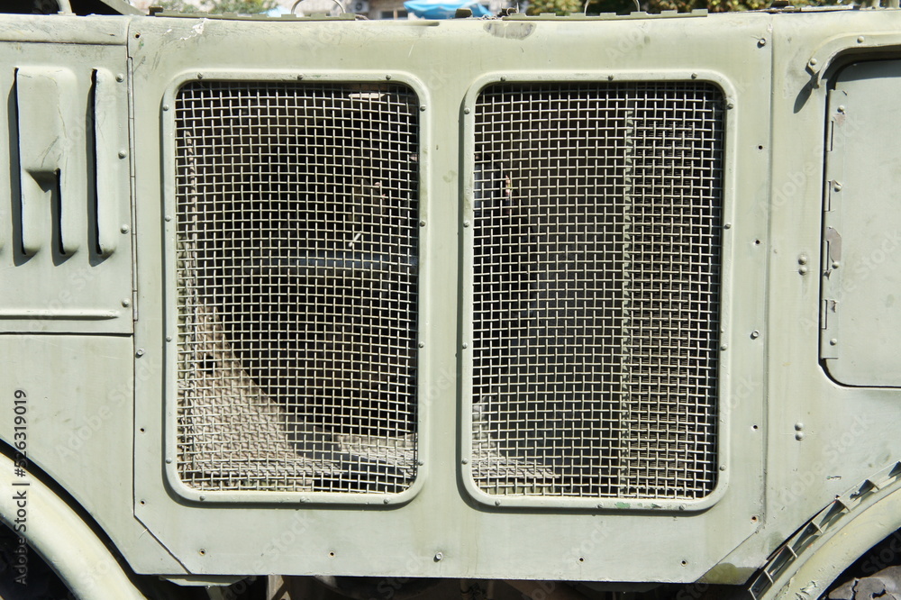 Lattice texture close up. Holes of grey metal plate with round regular holes texture background. Military Texture. Lattice construction on military vehicles green protective colors