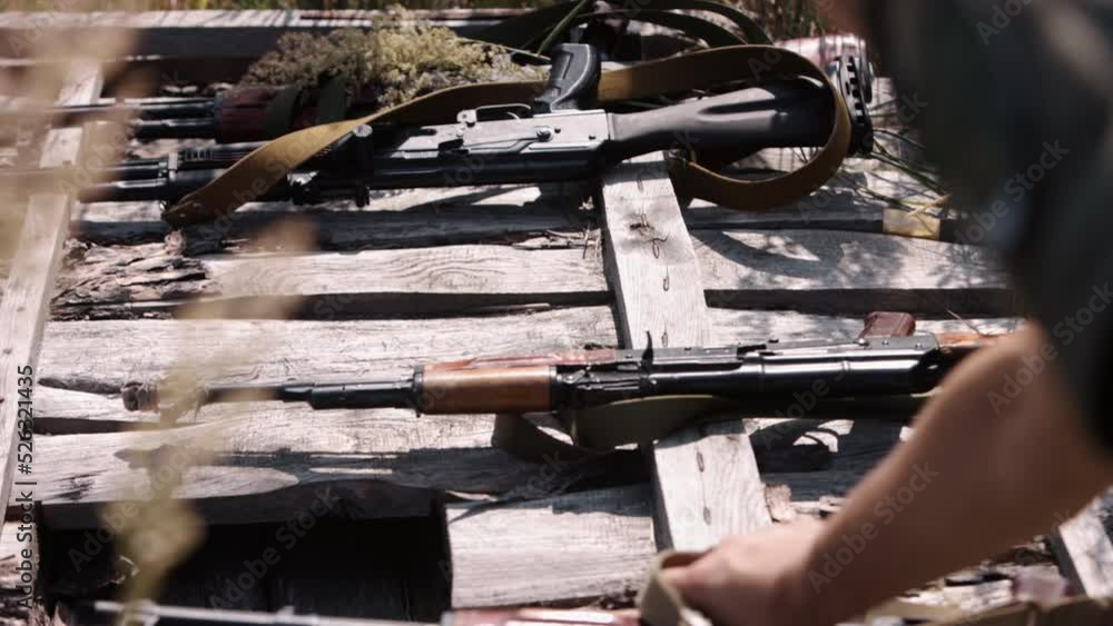 A close-up of a soldier's hand placing a Kalashnikov AK47 machine gun ...