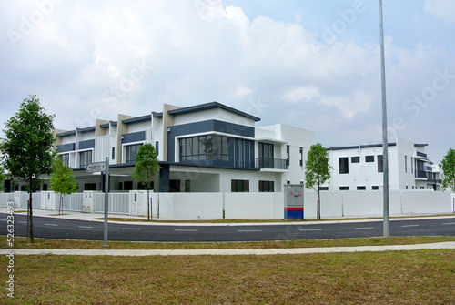 SELANGOR, MALAYSIA - JUNE 18, 2022: New double-story terrace house under construction in Malaysia. This house has a wide front porch and is fenced. Has basic facilities. © Aisyaqilumar