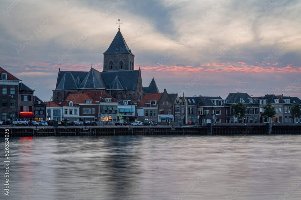 Church Buitenkerk along the river Ijssel in the city of Kampen by sunset