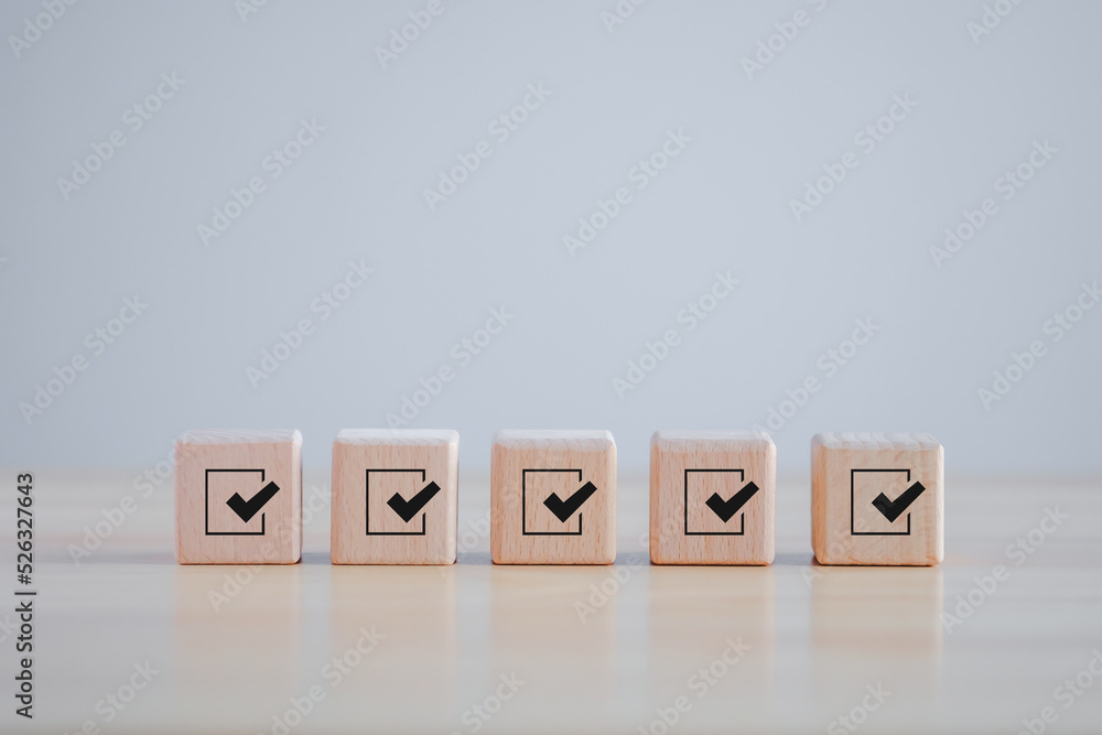Checklist, Task list, Survey and assessment. Quality Control. Goals achievement and business success. Check mark icon on wooden blocks. Checklist, Task list, Survey and assessment. Quality Control. Goals achievement and business success. Check mark icon on wooden blocks.