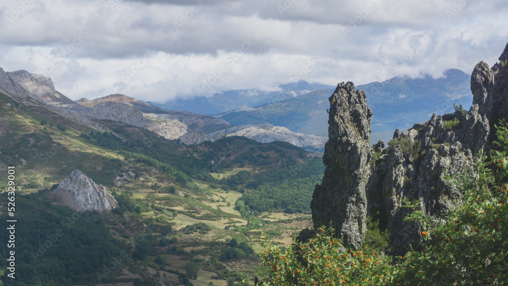 Mountain range covered in green grass and in a cloudy day