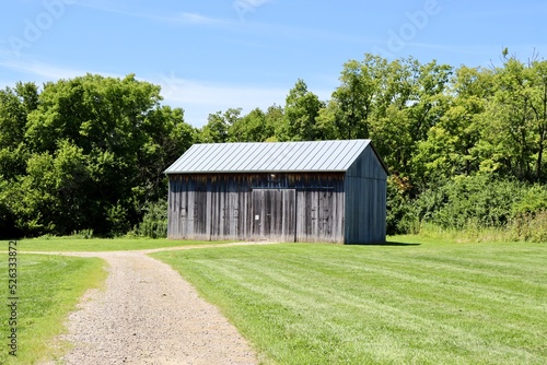 The old wood barn in the country on a sunny day.