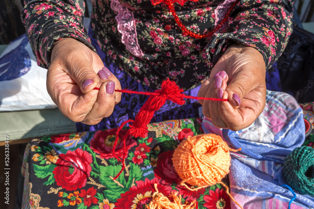 A woman needlewoman makes ancient Slavic dolls amulets from threads A woman needlewoman makes ancient Slavic dolls amulets from threads