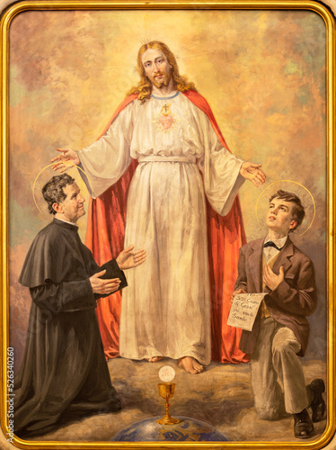 BIELLA, ITALY - JULY 15, 2022: The painting of Heart of Jesus with the St. Don Bosco and Dominic Savio in the church Chiesa di San Casiano by Paolo Giovanni Crida (1963).
