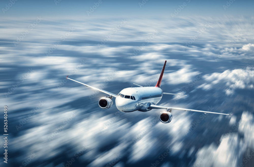 Obraz premium Airplane is flying above the low clouds in summer