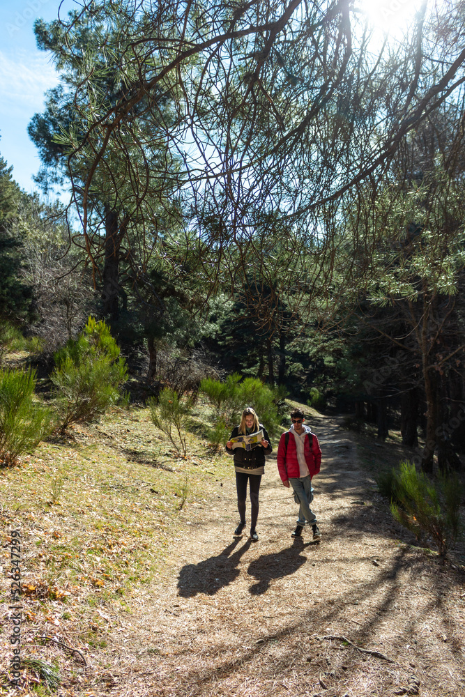 Obraz premium Two friends looking a map in the middle of the nature