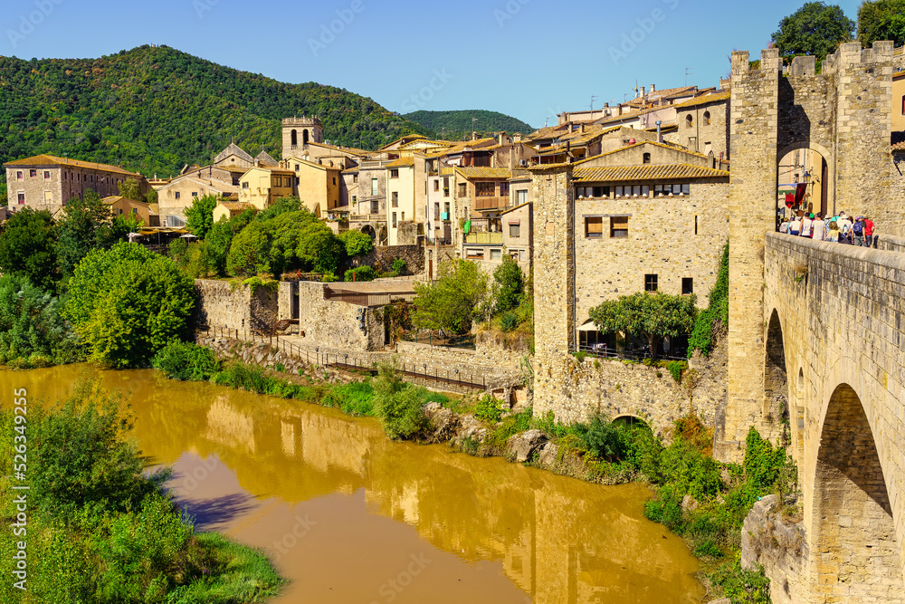 Old stone houses on the river and reflection in the water, Besalu Gerona Spain.