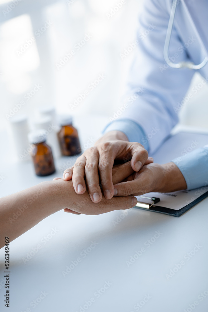 Obraz premium Doctor shook hands to encourage the patient after informing the results of the examination and informing the patients about treatment guidelines and prescribing medicines. Disease examination concept.