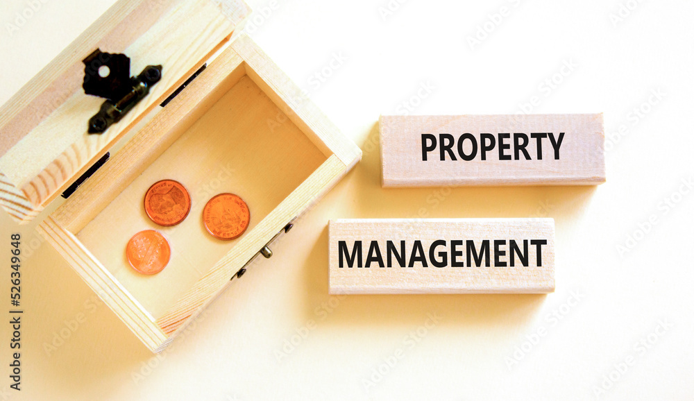 Property management symbol. Concept words Property management on wooden blocks on a beautiful white table white background. Wooden chest with coins. Business property management concept. Copy space. Property management symbol. Concept words Property management on wooden blocks on a beautiful white table white background. Wooden chest with coins. Business property management concept. Copy space.