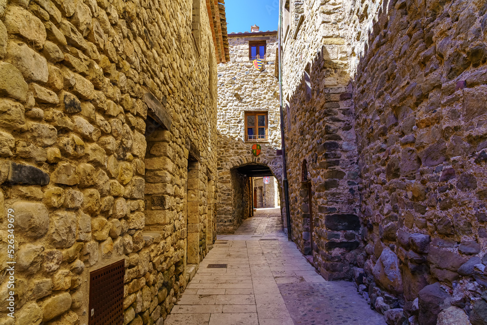 Picturesque narrow alley with houses built entirely of stone in the medieval town of Besalu, Girona.
