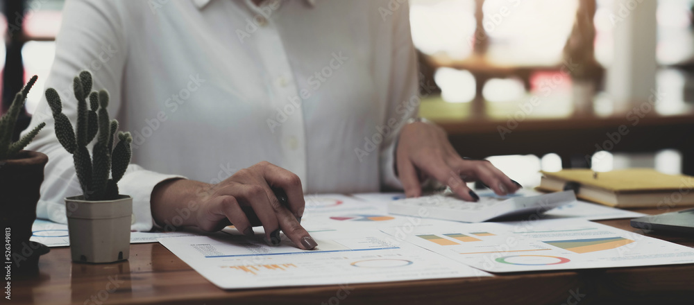 Businesswoman using calculator working at office with reports document financial.