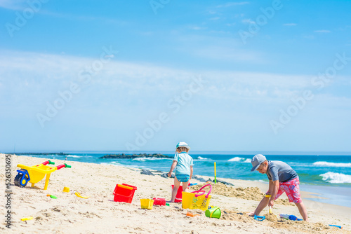 Fototapeta Naklejka Na Ścianę i Meble -  Brother and sister are building a sand castle on the sea shore
