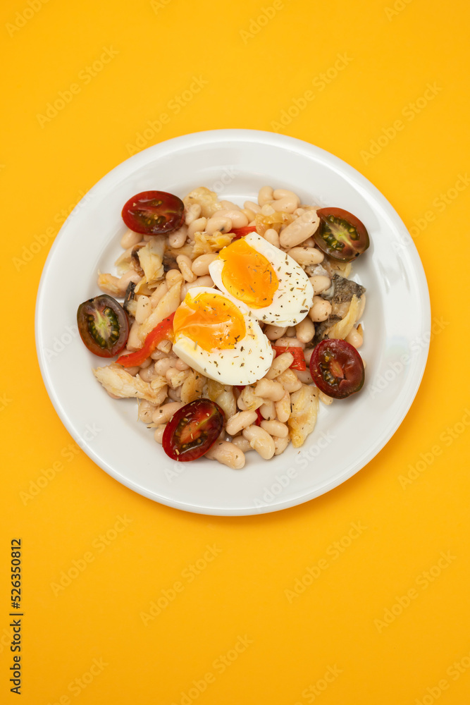 Salad with Fried cod fish and white beans on the plate on ceramic. Salad with Fried cod fish and white beans on the plate on ceramic.