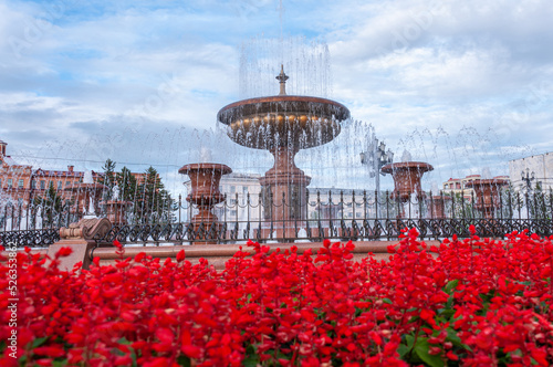 Khabarovsk, Russia, July 17, 2022: A large fountain in the center of Lenin Square on a summer day and red flowers photo