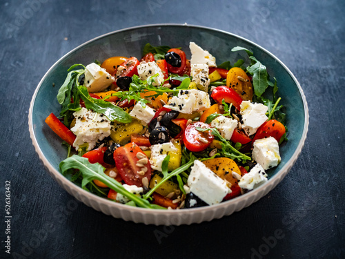 Fresh vegetable salad with feta cheese on wooden table 