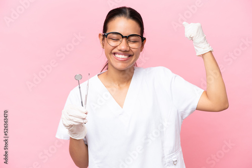 Dentist Colombian woman isolated on pink background doing strong gesture