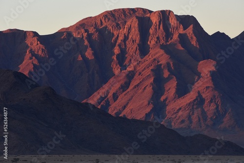Die Berge des Naukluft Gebirge leuchten rot im Licht der untergehenden Sonne. 