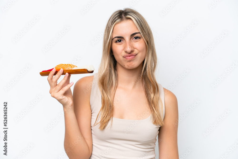 Young caucasian woman holding sashimi isolated on white background with sad expression Young caucasian woman holding sashimi isolated on white background with sad expression