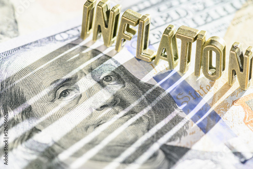 Inflation and consumer spending, financial concept : Word INFLATION on a US dollar note with a long shadow, depicting inflation that raise prices, lowering purchasing power, lowers currency valuation. photo