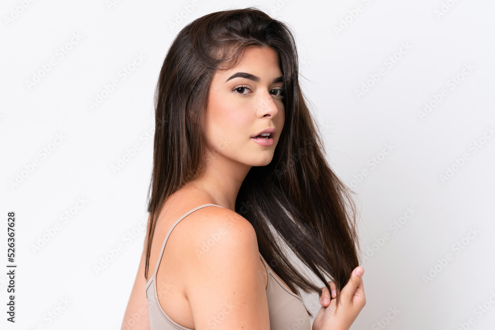 Fototapeta premium Young Brazilian woman isolated on white background touching her hair. Close up portrait